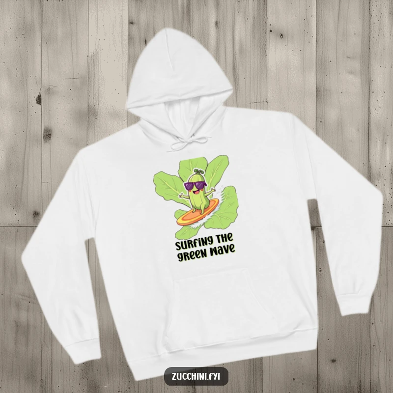 Giggling zucchini in sunglasses surfing on a lettuce leaf, a cool and humorous hoodie.